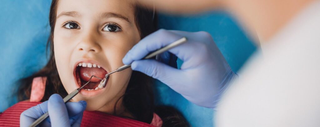 A child having their teeth examined by the dentist.
