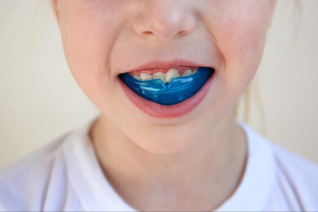 Super close-up of young boy's mouth with a mouthguard protecting his teeth.